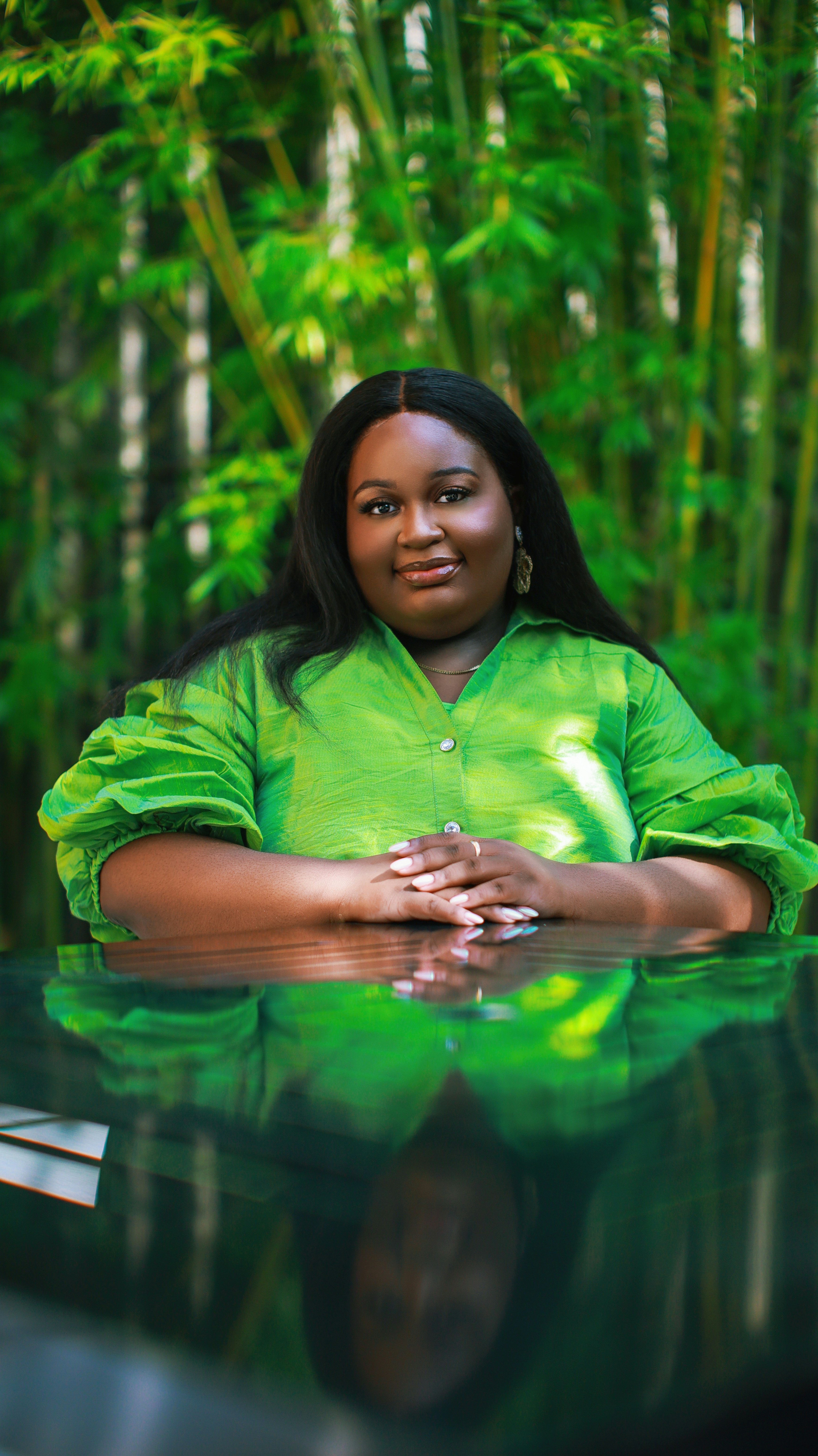 Portrait of a woman in a green dress in a bamboo garden.