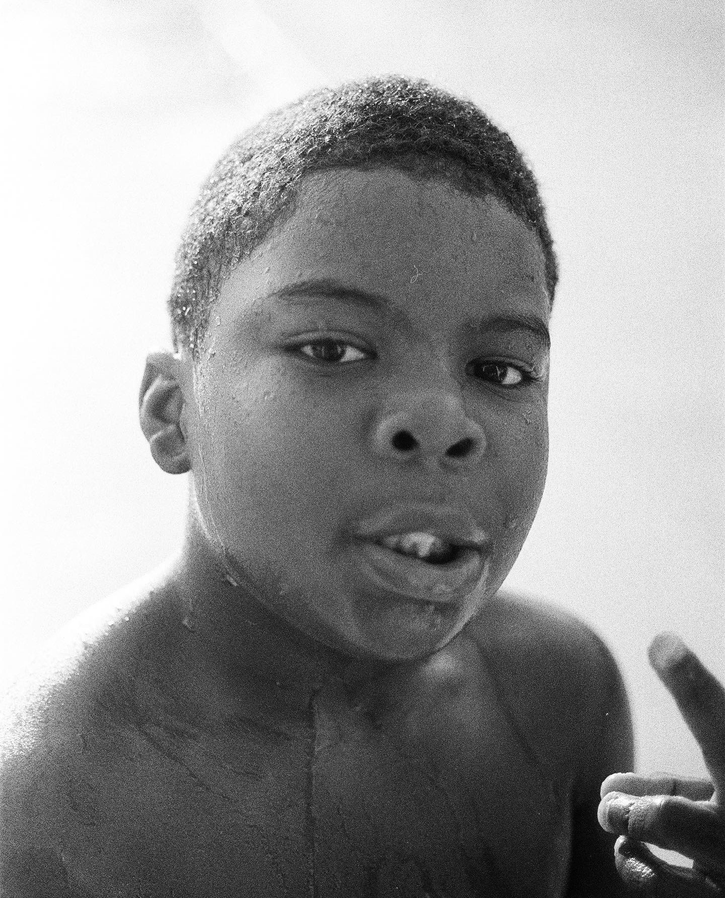 Black-and-white portrait of a boy with a gap-toothed smile.